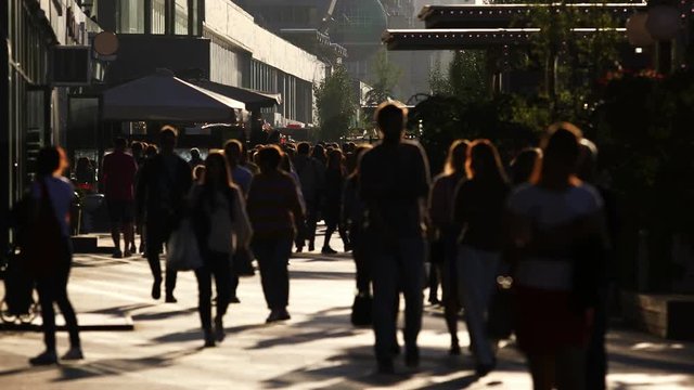 The flow of people is on the sunlit streets of the city, real time. Blurred bokeh
