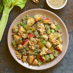 Quinoa Waldorf Salad with apple, celery, yellow raisins and walnut served on plate, photographed overhead on slate with natural light