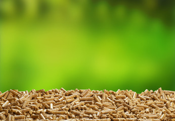 Organic wood pellets over green outdoor background