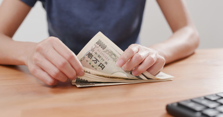 Woman counting Japanese banknote