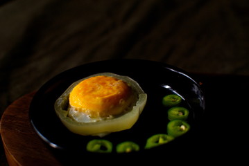fried eggs with bitter green pepper on a plate.