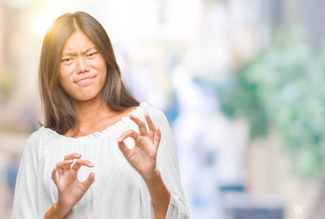 Young asian woman over isolated background disgusted expression, displeased and fearful doing disgust face because aversion reaction. With hands raised. Annoying concept.