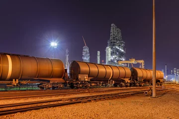Fototapeten Train wagons at an oil refinery at night, Port of Antwerp, Belgium © tonyv3112