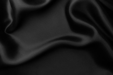 Elegant black satin silk with waves, abstract background.