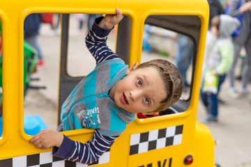 Surprised ukrainian boy in the taxi looks in the camera. Summer activities for children.