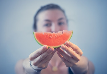 Junges Mädchen hält sich ein Stück Melone vor das Gesicht, Konzept