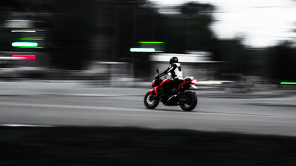Red motorcycle. In motion. Photo with minimal wiring. A little blurry photo as an artistic device. Speed. Adrenaline. Moto
