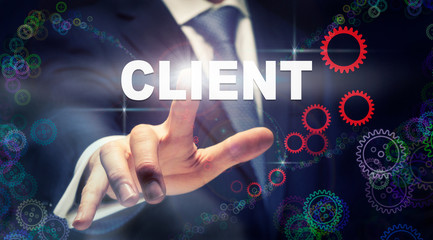 A businessman pressing a Client business concept on a graphical display of cogs