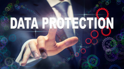 A businessman pressing a Data Protection business concept on a graphical display of cogs