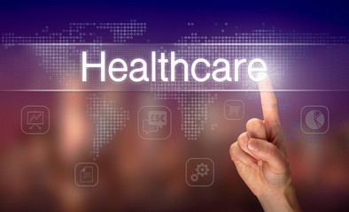 A hand selecting a Healthcare business concept on a clear screen with a colorful blurred background.