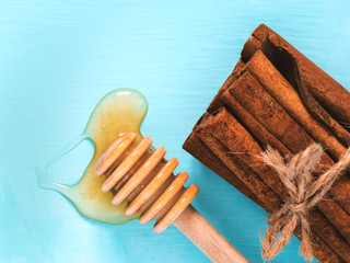 cinnamon sticks and spilled honey on blue