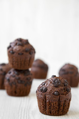 Chocolate muffins on white wooden surface, side view. Selective focus.