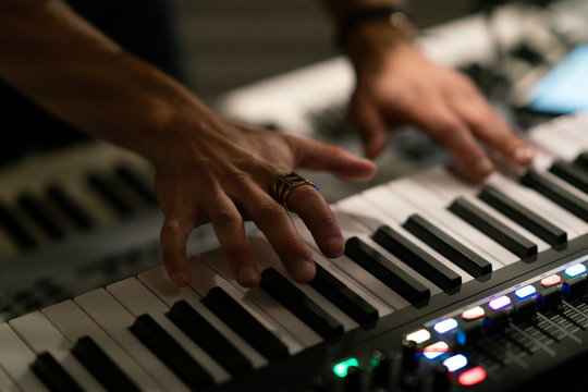 close up of hands playing keyboard