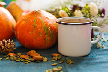 Cozy Autumn Morning with Cup of Coffee, Decorative Pumpkins, Nuts, Flowers, Cones. Halloween Mood