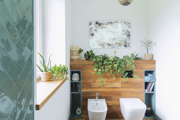 Cozy and mediterranean stylish bathroom in warm colours and natural wood. Wooden shelfs and white...
