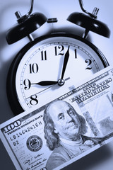Time is money. Alarmclock with Dollars cash as symbol of business, wealth and work.