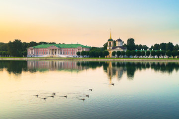 Obraz premium Fofmer aristocratic mansion and church with bell tower next to the palace pond in the State reserve museum Kuskovo, former summer country estate of the 18th century. Moscow. Russia.