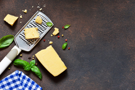 Parmesan cheese, garlic, basil on a concrete dark background. Ingredients for pasta. Advertising food.