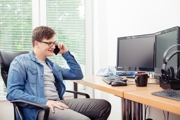 Young programmer talking on the mobile phone