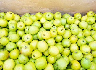 green apples background in wooden box at street market
