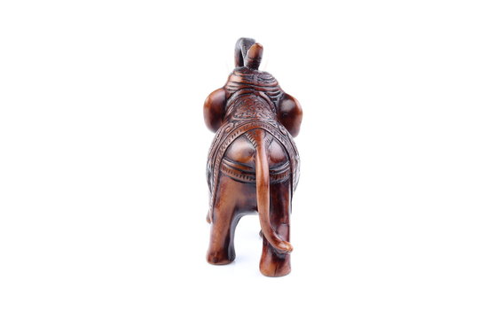 Brown Engraved pattern gold elephant made of resin like wooden carving with white ivory. Stand on white background, Isolated, Art Model Thai Crafts, For decoration Like in the spa.