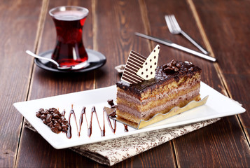 chocolate cake with tea on a wood background