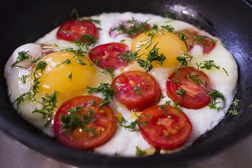 Fried eggs with tomatoes in a frying pan