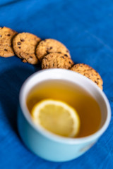 Tea with Lemon and Cookies with Chocolate Laying on Mattress