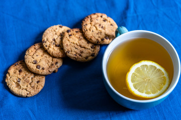 Tea with Lemon and Cookies with Chocolate Laying on Mattress