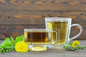 Herbal tea in transparent cups on wooden table