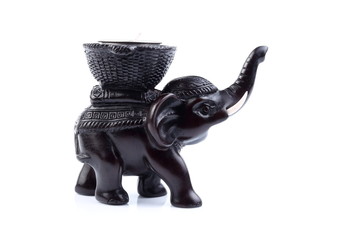 Black elephant made of resin like wooden carving with candle holder with white ivory. Stand on white background, Isolated, Art Model Thai Crafts, For decoration Like in the spa. Engraved pattern.