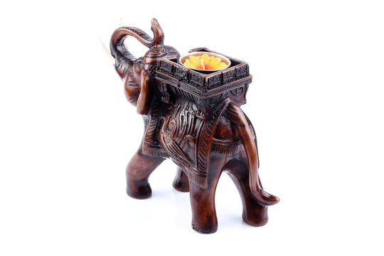 Brown Gold Black elephant made of resin like wooden carving with candle holder with white ivory. Stand on white background, Isolated, Art Model Thai Crafts, For decoration Like in the spa. Engraved pa