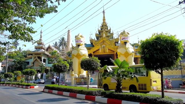 YANGON, MYANMAR - FEBRUARY 17, 2018: The North Gate of Shwedagon Pagoda with two huge leogryphs (chinthe) guardians and ornate spire above the covered gallery, on February 17 in Yangon.