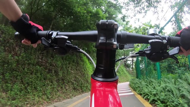 Riding bike on bicycle path in park, View from first person perspective POV - Point of view front  by action camera
