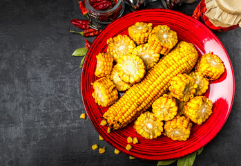 Tasty grilled corn on black wooden table