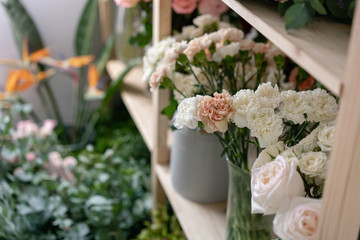 Fototapeta na wymiar Flower shop concept. Different varieties fresh spring flowers in refrigerator room for flowers. Bouquets on shelf, florist business.