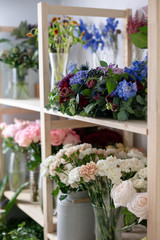 Flower shop concept. Different varieties fresh spring flowers in refrigerator room for flowers. Bouquets on shelf, florist business.