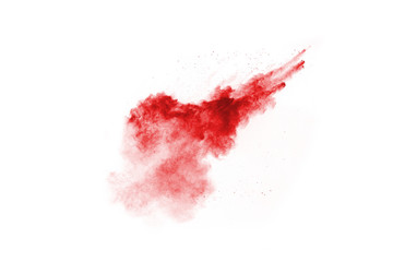 Freeze motion of red powder exploding, isolated on white background. Abstract design of red dust...