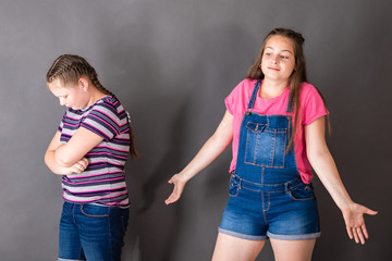 The older sister makes a helpless gesture, not knowing how to calm the insult of the younger