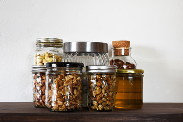 Glass jars with various kinds of nuts and honey