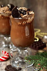Festive hot chocolate with whipped cream and cookies.