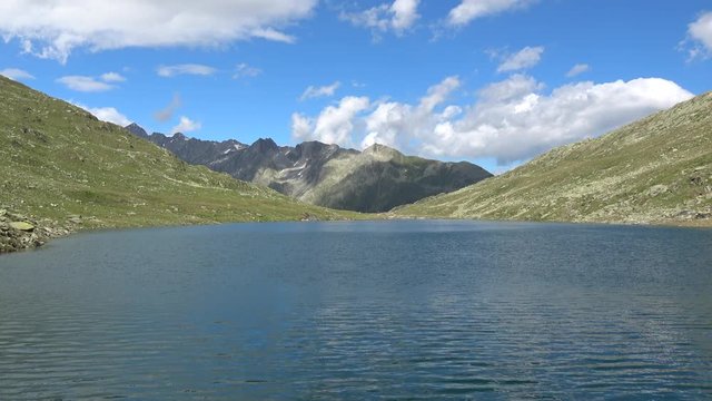 Scenic view on peak of mountains and lake in Swiss Alps. Summer landscape, sunshine weather, blue sky and sunny day