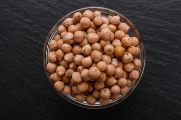 uncooked chickpeas on a dark stone background