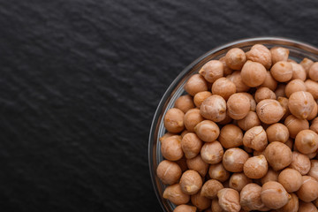 uncooked chickpeas on a dark stone background