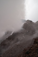 Etna vulcano surrealistic landscape mountain clouds fog lava stone 
