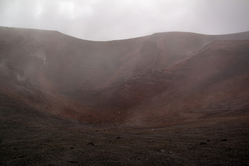 Etna vulcano surrealistic landscape mountain clouds fog lava stone 