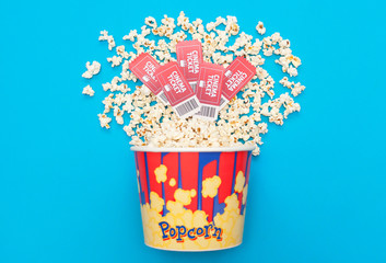 Cinema minimal concept. Watching film in the cinema. popcorn, tickets on a bright blue background....