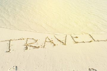 Written word Travel on sandy beach with copy space