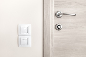 Door handle and white lighting switches on wall