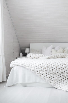 White nordic bedroom interior with knit plaid